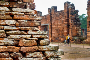 Close-up of wall with woman and child in the background in the Ruins of San Ignacio, Misiones, Argentina