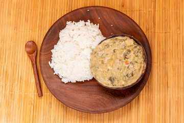 Traditional African Kale Stew with Coconut Milk and Peanut Flour, Served in a Coconut Shell with White Rice: A Delicious and Nutritious Dish from Mozambique