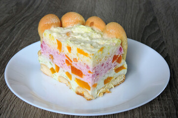 Easy no-bake jelly cheesecake with peaches and sponge fingers on a white plate