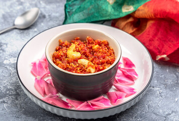 Gajar ka halwa is a traditional Punjabi dessert pudding from India made from carrots and served in a bowl. Garnished with cashew, almond and pistachio nuts