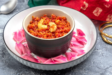 Gajar ka halwa is a traditional Punjabi dessert pudding from India made from carrots and served in a bowl. Garnished with cashew, almond and pistachio nuts