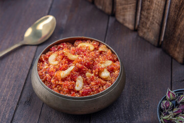 Gajar ka halwa is, Popular Indian dessert pudding made with grated carrots, milk, sugar and nuts served hot with a garnish of almonds, cashew nuts and pistachios.