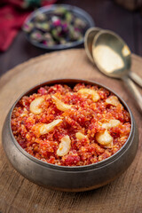 Gajar ka halwa is, Popular Indian dessert pudding made with grated carrots, milk, sugar and nuts served hot with a garnish of almonds, cashew nuts and pistachios.