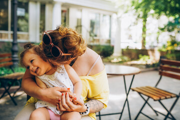 Happy mother and daughter laughing together outdoors
