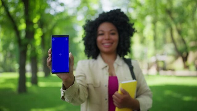 Smiling African American woman showing phone with pre-keyed screen, mobile app