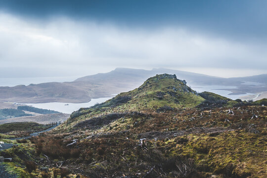 A photo overseeing the landscape of Isle of Skye in Scotland, the atlantic ocean in the far and a cloudy grey sky