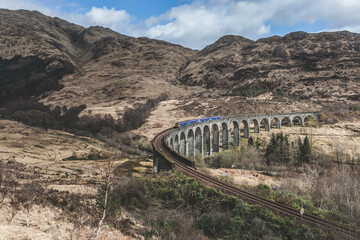 A historic train bridge from the movie Harry Potter passing through a beautiful landscape 
