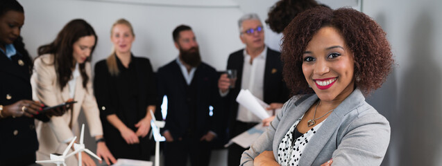 Close-up latin businesswoman posing at camera with smile. Teamwork working at desk office on...