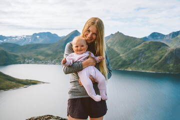 Mother with infant baby outdoor family lifestyle travel together in Norway summer vacations woman...