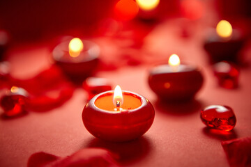 Romantic dinner decoration. Red candles, flower petals, on the table