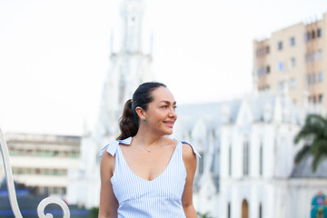 Beautiful tourist woman at the Ortiz Bridge with La Ermita church on background in the city of Cali...