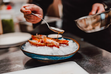 chef cooking crab legs with caviar on kitchen