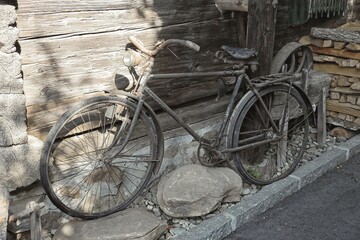 old bicycle leaning on a wooden wall