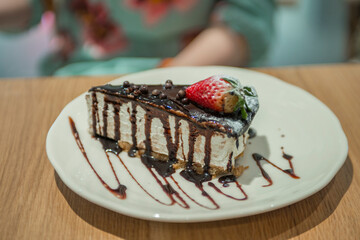 close-up of a cake with strawberries on a plate in a cafe