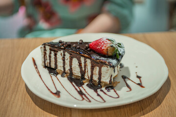 close-up of a cake with strawberries on a plate in a cafe