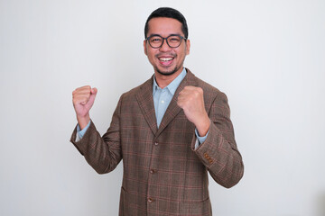 Asian businessman wearing brown suit clenching both hand showing success gesture