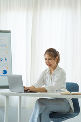 Attractive asia employees in successful modern office university education Financial graphs on her workstation. Young asian freelance employee online marketing ecommerce telemarketing concept report