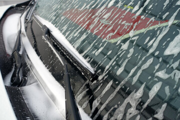 car wash with foam, foamed front auto glass, close-up foamed car,