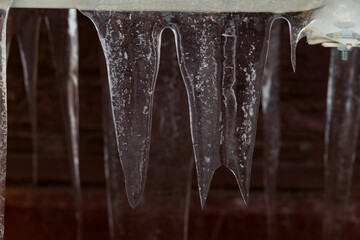 Big flat icicles hanging from an air conditioner.