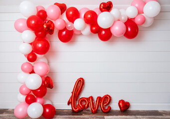 Valentine's Day balloon arch on white shiplap wall