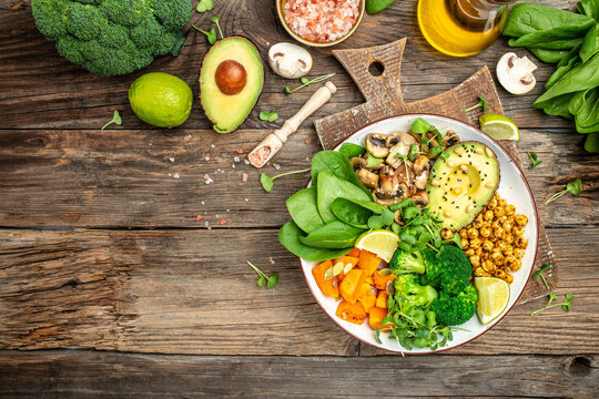 Green vegetable vegan salad with avocado, mushrooms, broccoli, spinach, chickpeas, pumpkin. Healthy vegetarian food concept. top view