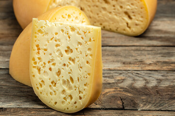 Emmental cheese triangle, Swiss cheese. piece of cheese maasdam with big holes. farmer market. banner, menu, recipe place for text