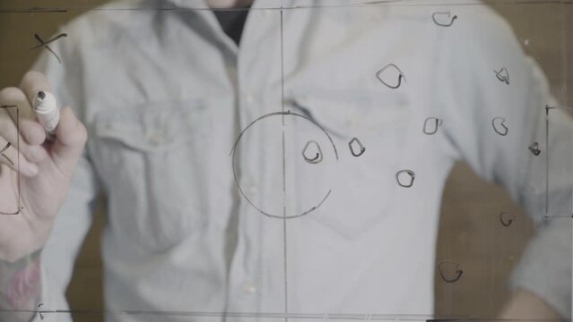 Football tactics with black color marker on a glassboard, training concept