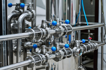 Close-up of steel tanks with chemical materials with pipes with levers in production factory