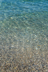 Texture of turquoise sea water with stones
