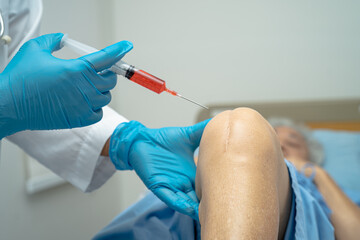 Asian doctor inject Hyaluronic acid platelet rich plasma into the knee of senior woman to walk...
