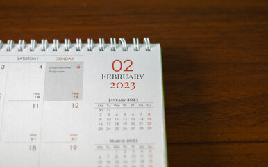 Top view of 2023 calendar. First page "January". Selective focus shot of a calendar, focused on "01, January, 2023".