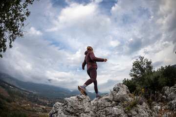 Obraz premium Successful female hiker hiking on a mountain peak.