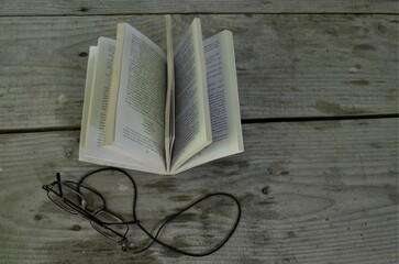 book with glasses on wooden table