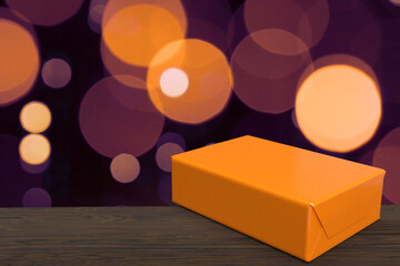Golden bokeh with an orange gift.
