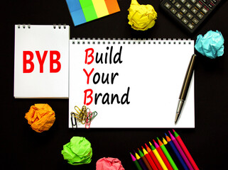 BYB build your brand symbol. Concept words BYB build your brand on white note on a beautiful black background. Calculator. Business and BYB build your brand concept. Copy space.