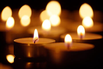 Burning candles on black background, shot with shallow depth of field
