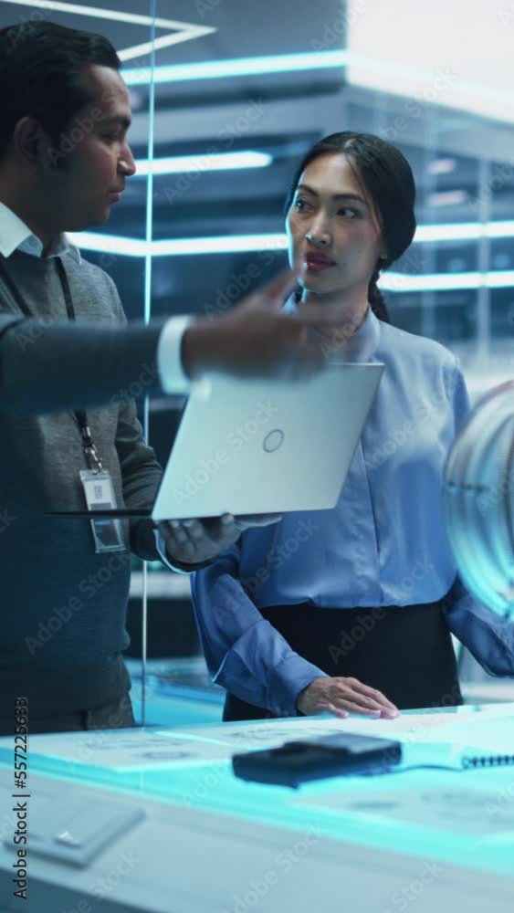 Leinwandbilder vertical screen: two multiethnic employees work in modern innovative research facility on a project.