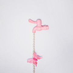 Dripping tap, creative aesthetic concept, pastel pink butterfly. Springtime natural layout. 