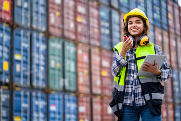 Female worker working in a shipping port Order to talk via walkie-talkie at the container yard, export and import goods. Concept of inventory and logistic management.