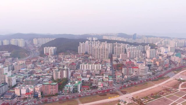 Ulsan: Aerial view of city in South Korea, modern high-rise buildings (skyscrapers) at sunset, trees in autumn colors, Taehwagang National Garden - landscape panorama of Eastern Asia from above