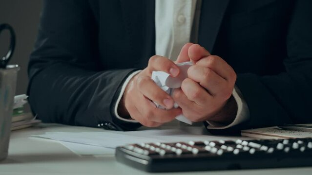 Aggressive man crumpling paper, stress at work concept. Mad impulsive crazy adult guy throwing away the documents, angry office worker 