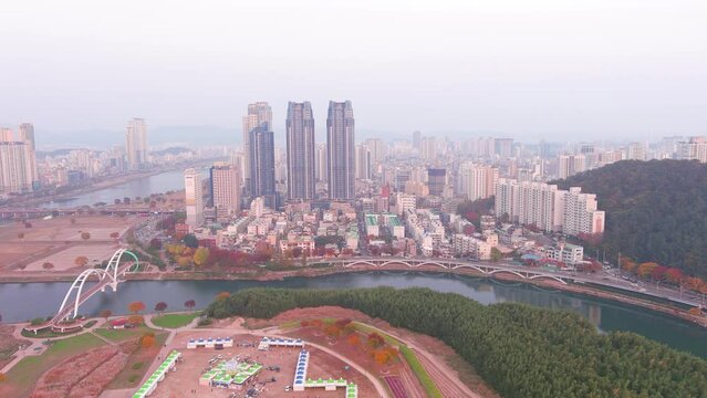 Ulsan: Aerial view of city in South Korea, modern high-rise buildings (skyscrapers) at sunset, trees in autumn colors, Taehwagang National Garden - landscape panorama of Eastern Asia from above