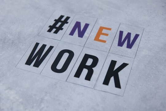 Letters on concrete background saying "#newwork". New work concepts. Home office and hybrid working. Symbol image for changing work environment. Remote work concepts. Social distancing and lockdown. 