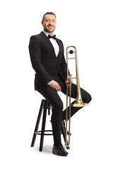 Male musician in a black suit and bow-tie sitting on a chair with a trombone
