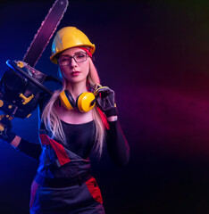 sexy girl with a chainsaw in a construction jumpsuit and helmet on a black background in neon light