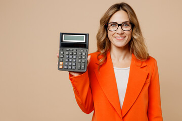 Young minded employee business woman corporate lawyer wear classic formal orange suit glasses work in office hold in hand show calculator with empty screen isolated on plain beige background studio.
