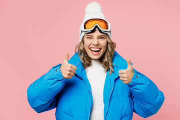 Snowboarder woman wear blue suit goggles mask hat ski padded jacket spend extreme weekend showing thumb up like gesture isolated on plain pastel pink background. Winter sport hobby trip relax concept.