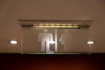 Toilet sign hanging on ceiling