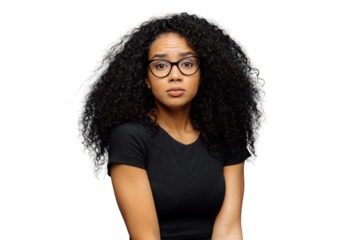 Photo of indignant puzzled Afro American woman looks surprisingly at camera, wears casual black t shirt and spectacles, poses against blue background. Human facial expressions and feelings concept