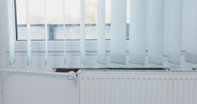 Moving vertical blinds, hung in the room by the window. Central heating.